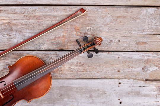 Violin and fiddle stick, cropped image. Vintage cello and bow on old wooden boards and text space. Symbol of classical music.