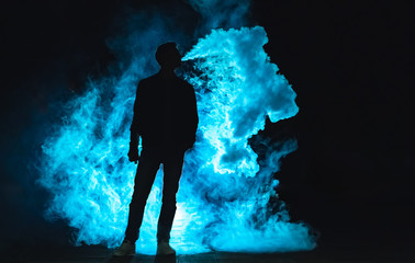 The man smoking on the dark background