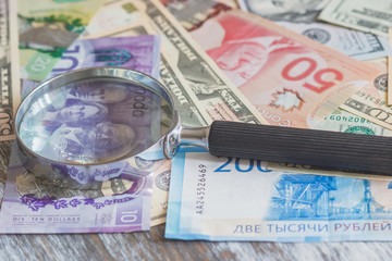 Currency and a magnifying glass, soft focus background