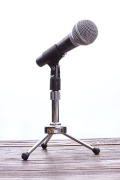 Grey mini microphone on stand. Professional microphone on short rack stand, vertical image. Modern technology concept.