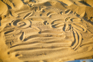 Drawing on the sand made by a child close-up