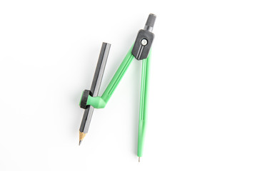 Green plastic compass with pencil and protractor on a white background