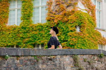 Young girl in hat at bridge in Bruges, Belgium. Autumn season.