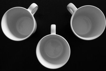 Empty white cups on black wooden table