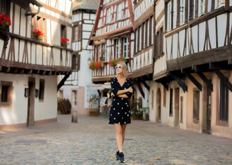 Young style girl in black dress walking down the street in Strasbourg, France, Autumn season time - obrazy, fototapety, plakaty