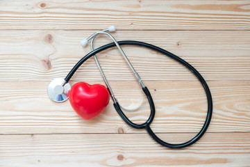 Stethoscope with Red heart shape on wooden background. Healthcare and Insurance concept