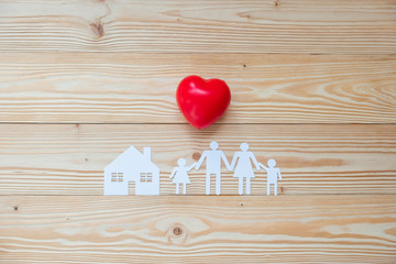 Red heart shape with Family and House paper on wooden background. Healthcare and Insurance concept