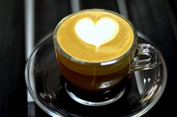 café en taza transparente con arte latte de corazon