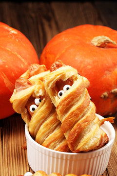 Mummy sausages scary halloween party food decoration wrapped in dough.