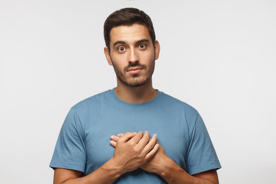 Kind Hearted Friendly Nice Guy Shows Kindness, Wearing Blue T-shirt. Smiling Positive Young Man Keeps Hands On Chest, Expresses Sympathy