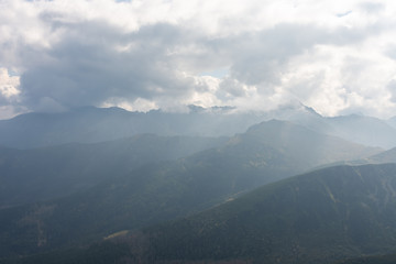 Naklejka premium Beautiful wooded mountains covered with fog. Polish tatras.