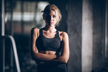 Attractive builder muscles women in fitness gym and looking camera