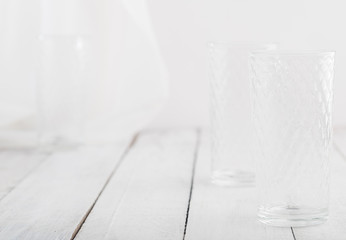 Empty glass on white wooden table. Space for text.