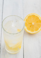 Lemon juice detox water. Mineral water infused with lemons. Wooden white table.