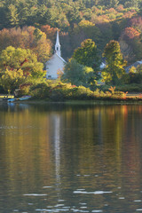 little church reflected in a pond in new england