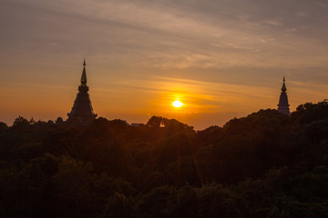 Obraz premium sunset between Noppamethanedol and Noppapol Phumsiri pagoda on Doi Inthanon national park..Doi Inthanon national park is the highest mountain of Thailand