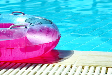 Pink inflatable round tube in swimming pool