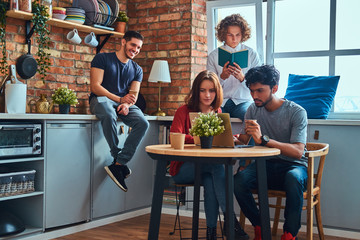 Kitchen in student dormitory. Group of interracial students engaged in education.