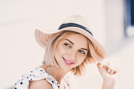 Portrait Beautiful young blonde girl in modern hat with full lips  posing and smiling on  the street lifestyle  on sunny day 