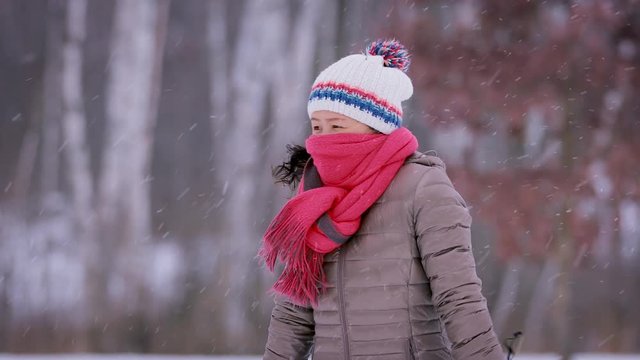 Asain woman freezing on a cold winter day.