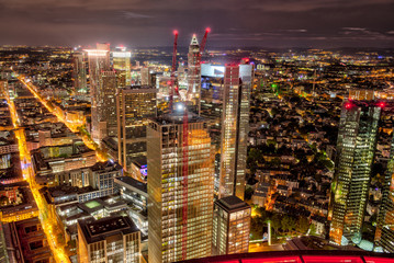 Die Hochhauskulisse von Frankfurt am Main am Abend bei künstlicher Beleuchtung