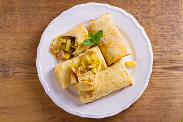 Apple cinnamon crepes. Pancakes with caramelized apples and cinnamon. View from above, top studio shot