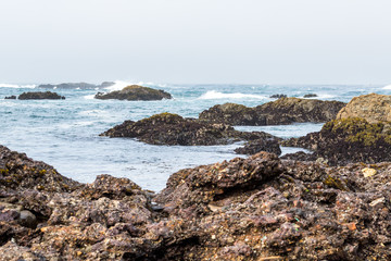 Fototapeta na wymiar Piles of refuse forming reefs at glass beach