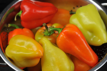 Pepper sweet Bulgarian in a deep bowl. Color of peppers is green, orange, red. View from above. Close-up. Macro photography.