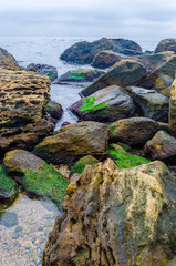 The photo of the stone on the beach on the long exposure