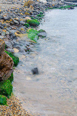 The photo of the stone on the beach on the long exposure