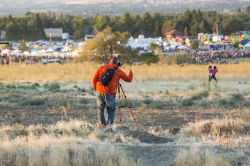 Photographer watching hot air balloons blow up from afar