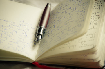 Close-up of pen on written notepad