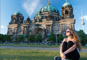 thoughtful girl tourist sitting in germany near berlin cathedral. berlin cathedral view in germany...