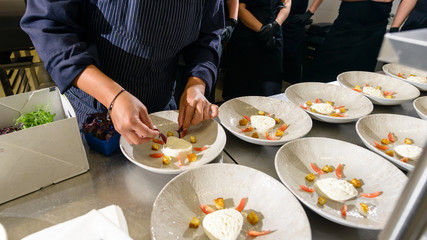 Chef hands sprinkling sesame on salad with tuna