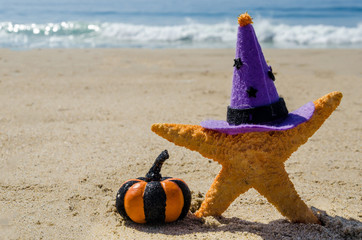 Halloween background on the beach with starfishes in witch's hats