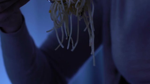 Sad woman eating spaghetti and crying, suffering from bulimia, homeless shelter