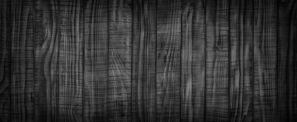 Panorama of black wooden boards, gloomy wood texture, dark background