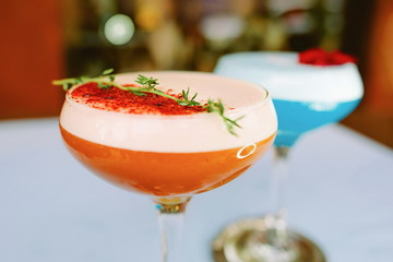 Blue curacao and beidge cocktails standing on the table outdoor