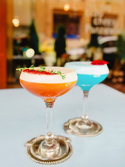 Blue curacao and beidge cocktails standing on the table outdoor
