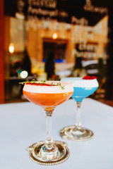 Blue curacao and beidge cocktails standing on the table outdoor