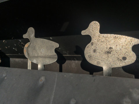Close-up Shooting Gallery Metal Ducks With Pellet Impacts, Black Background, Steel, Silver, Shooting.