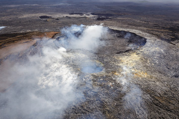 Smoking caldera of the Puu Oo vent with smaller crater in the foreground, Big Island, Hawaii. Aerial photograph out of a helicopter.