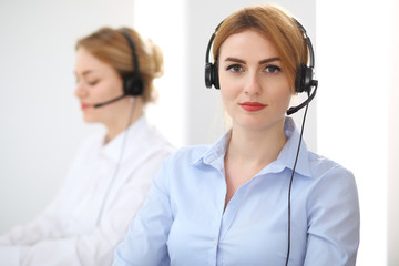 Call center. Focus on beautiful woman in headset