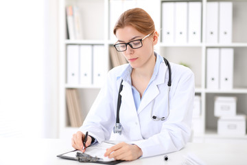 Young brunette female doctor at work in hospital.  Physician ready to help. Medicine and healthcare concept