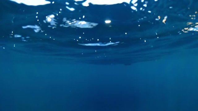Slow motion underwater footage of life buoys in the sea at sunny day