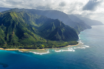 View on the mountains of Kauai's north coast with Kee Beach and the reef from Kailio Point. Na Pali Coast is in the background. Aerial shot from a helicopter, Kauai, Hawaii. - obrazy, fototapety, plakaty