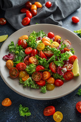 Fresh Cherry Tomato mix salad with lettuce, lemon, lime, black pepper and sea salt. healthy food
