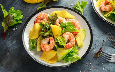 Fresh Shrimps, Avocado, Mango salad with lettuce green mix, herbs, lemon, healthy food.