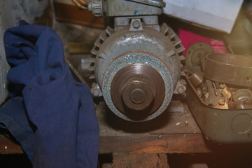Old rusty selfmade bench grinder on the workbench with lens flare