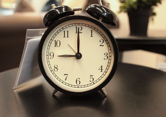 black retro alarm clock with bell on the table
